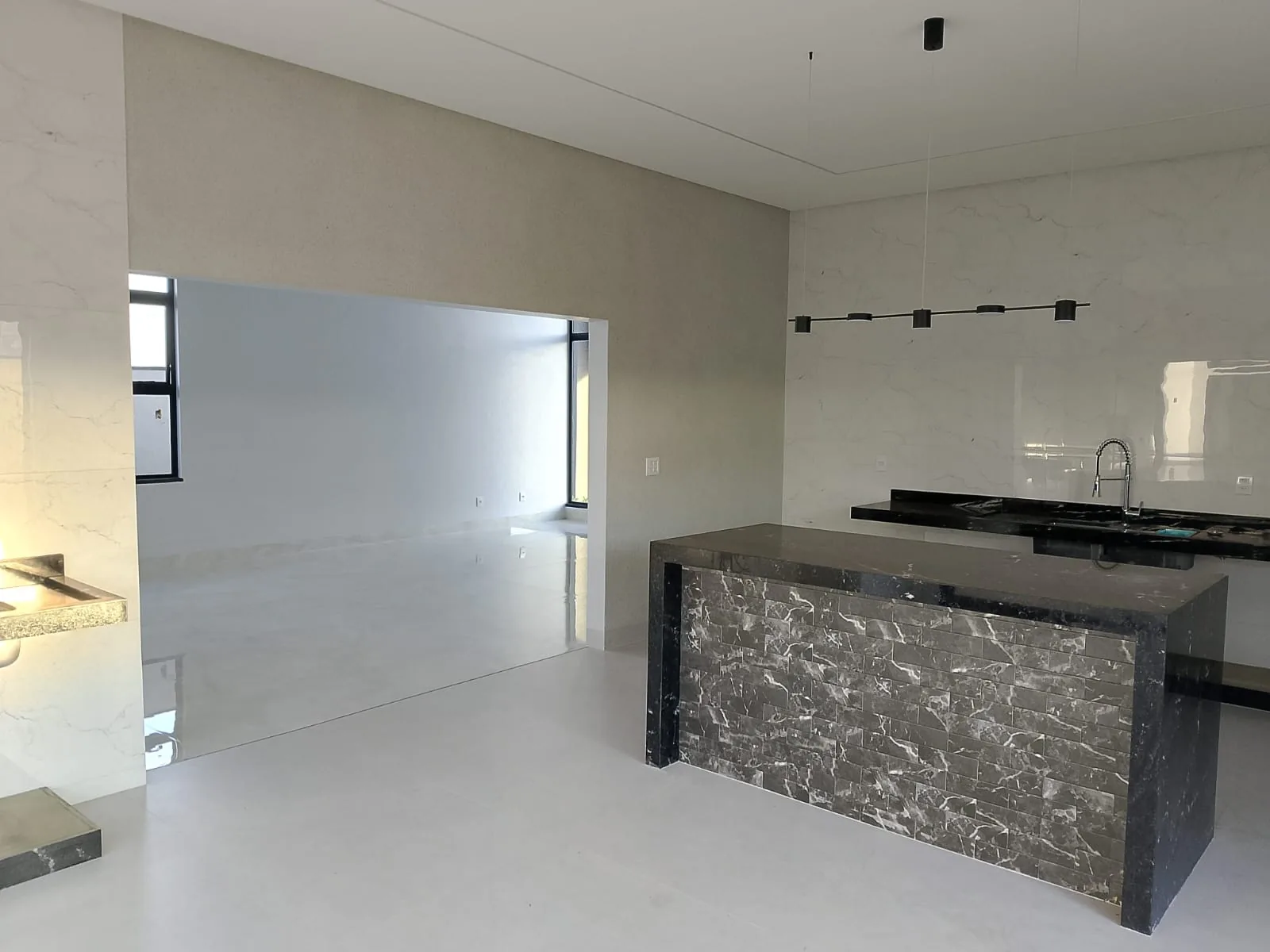 Cozinha finalizada com ilha de mármore e piso polido